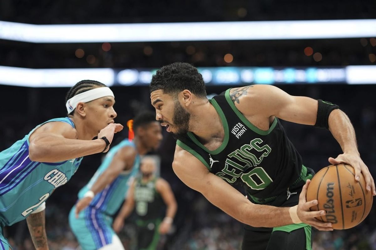 Apr 1, 2024; Charlotte, North Carolina, USA; Boston Celtics forward Jayson Tatum (0) handles the ball against Charlotte Hornets guard Tre Mann (23) during the first quarter at Spectrum Center.