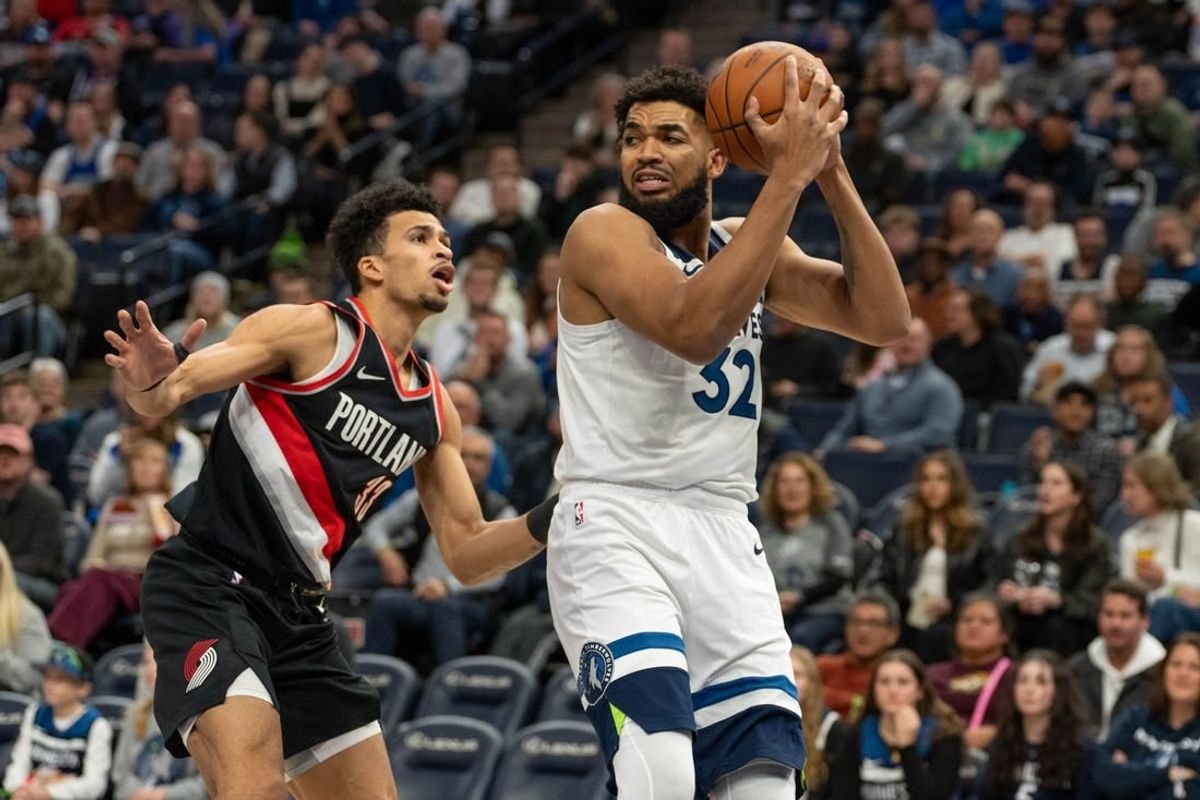 Jan 12, 2024; Minneapolis, Minnesota, USA; Minnesota Timberwolves center Karl-Anthony Towns (32) looks for a teammate defended by Portland Trail Blazers forward Toumani Camara (33) in the first quarter at Target Center.