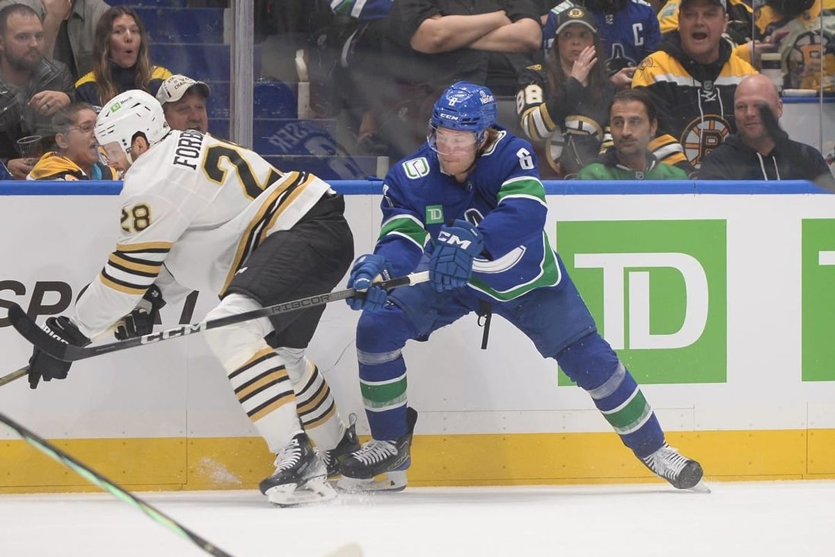 Feb 24, 2024; Vancouver, British Columbia, CAN;  Vancouver Canucks forward Brock Boeser (6) battles for the puck against Boston Bruins defenseman Derek Forbort (28) during the first period at Rogers Arena.