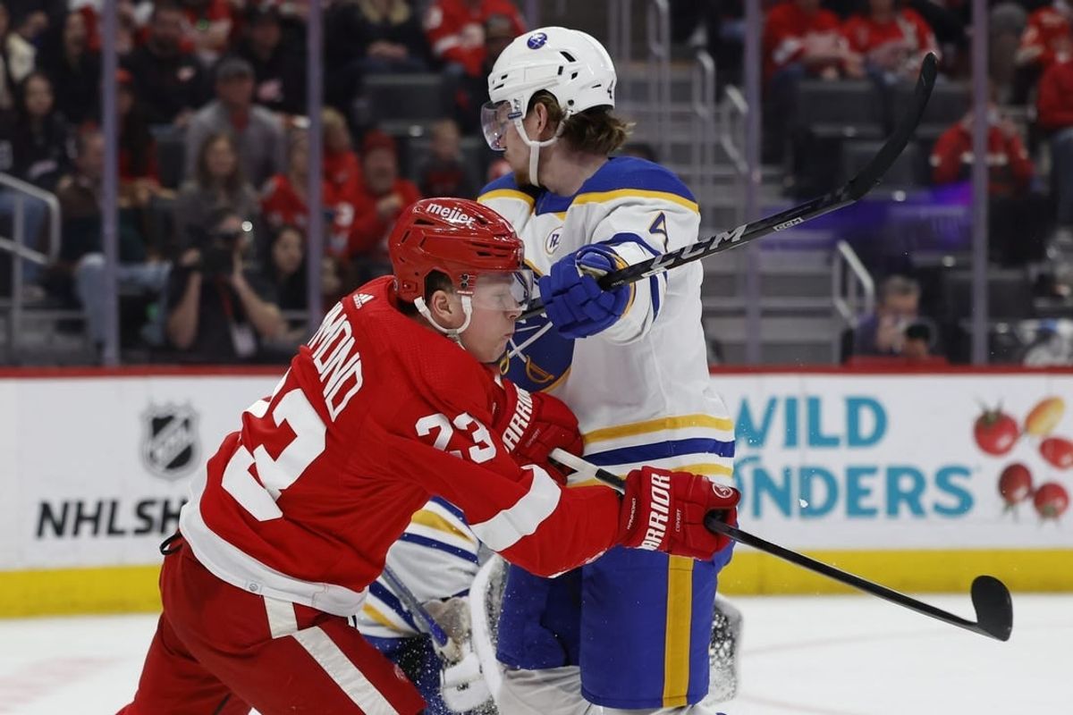 Apr 7, 2024; Detroit, Michigan, USA; Detroit Red Wings left wing Lucas Raymond (23) and Buffalo Sabres defenseman Bowen Byram (4) fight for position in the second period at Little Caesars Arena.