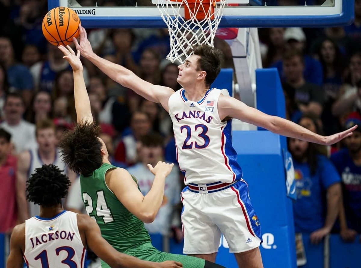 Nov 10, 2023; Lawrence, Kansas, USA; Kansas Jayhawks forward Parker Braun (23) blocks the shot of Manhattan Jaspers forward Xinyi Li (24) during the first half at Allen Fieldhouse.