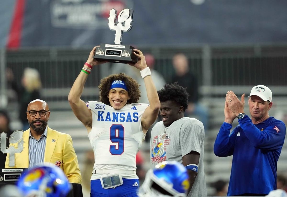 Dec 26, 2023; Phoenix, AZ, USA; Kansas Jayhawks quarterback Jason Bean (9) celebrates with the trophy after defeating the UNLV Rebels at Chase Field.