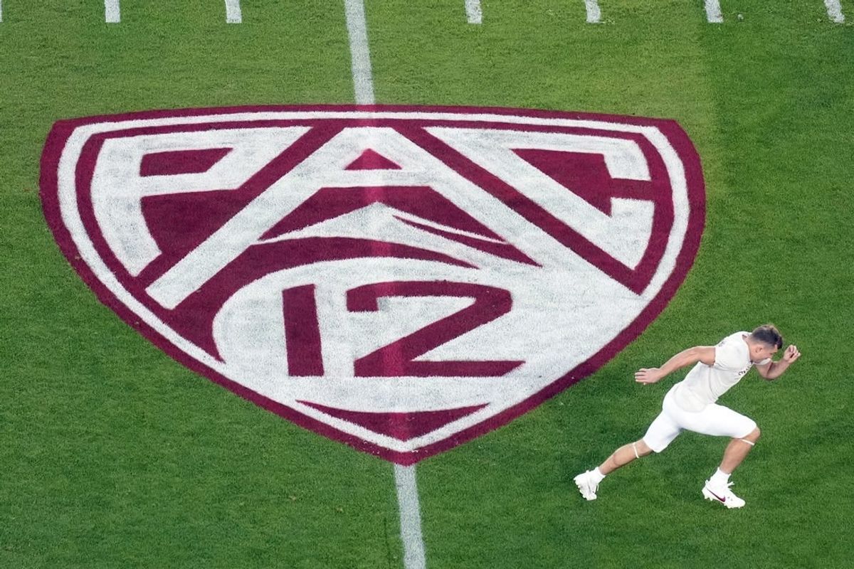 Oct 21, 2023; Stanford, California, USA; A view of the Pac-12 logo on the field as Stanford Cardinal wide receiver David Kasemervisz (80) warms up before the game against the UCLA Bruins at Stanford Stadium.