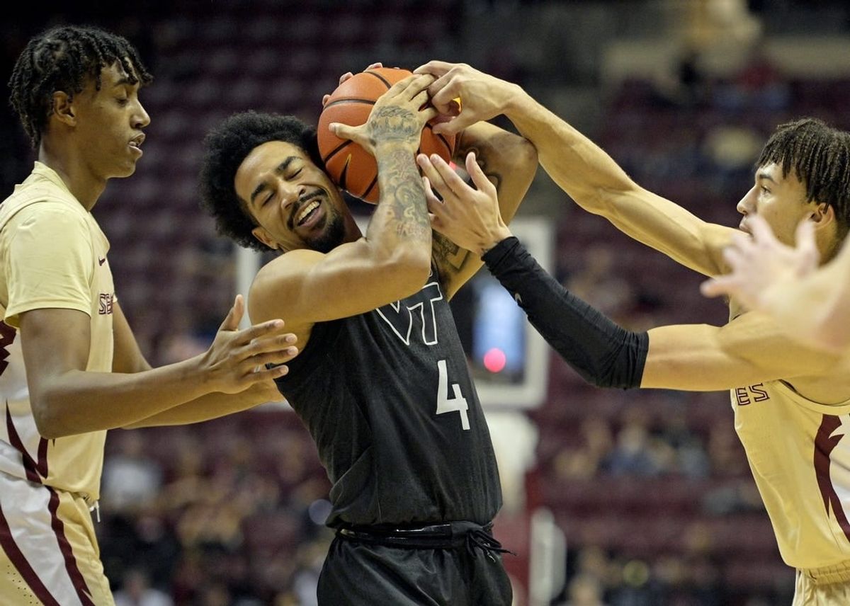 Jan 6, 2024; Tallahassee, Florida, USA; Virginia Tech Hokies forward Mekhi Long (4) wrestles a ball away from Florida State Seminoles guard Jalen Warley (1) during the game at Donald L. Tucker Center.