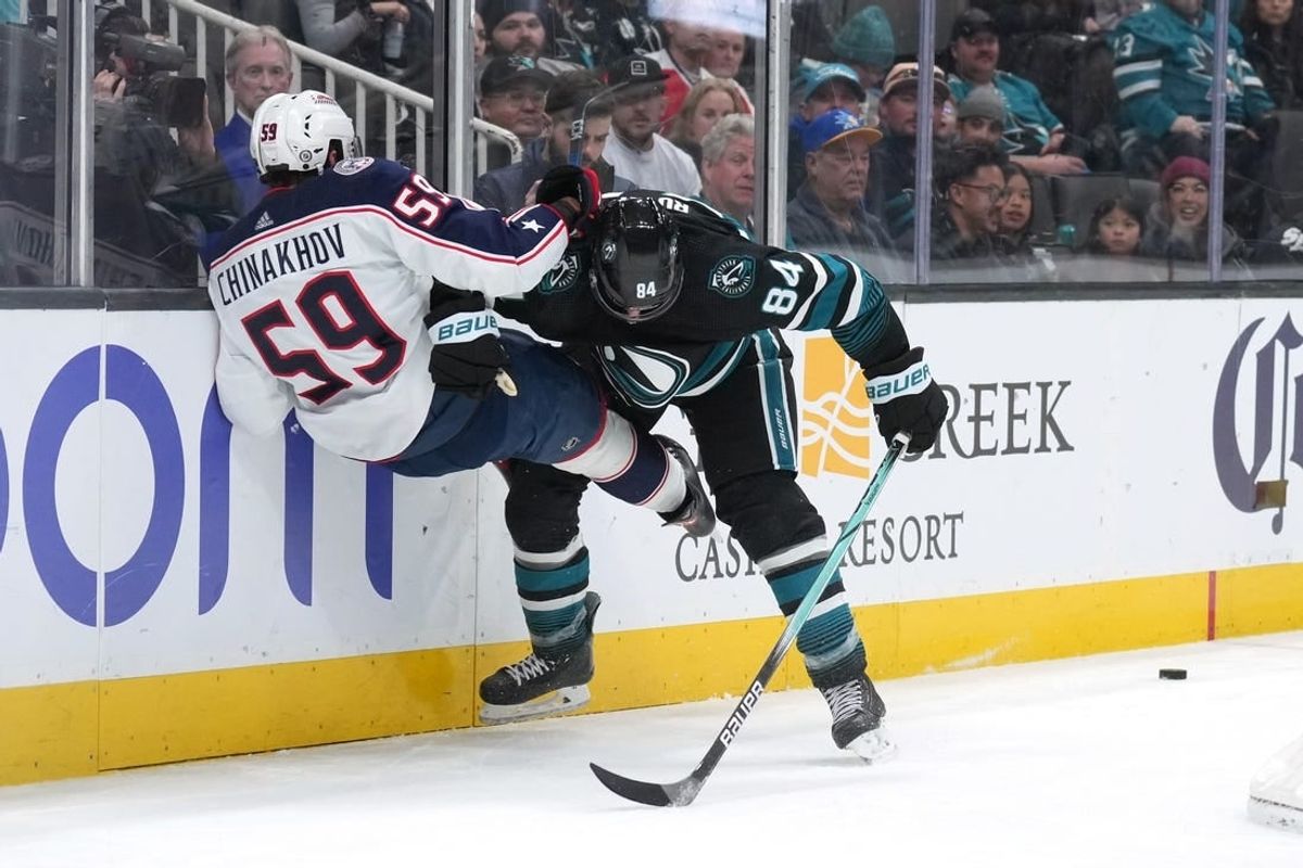 Feb 17, 2024; San Jose, California, USA; San Jose Sharks defenseman Jan Rutta (84) checks Columbus Blue Jackets right wing Yegor Chinakhov (59) during the first period at SAP Center at San Jose.