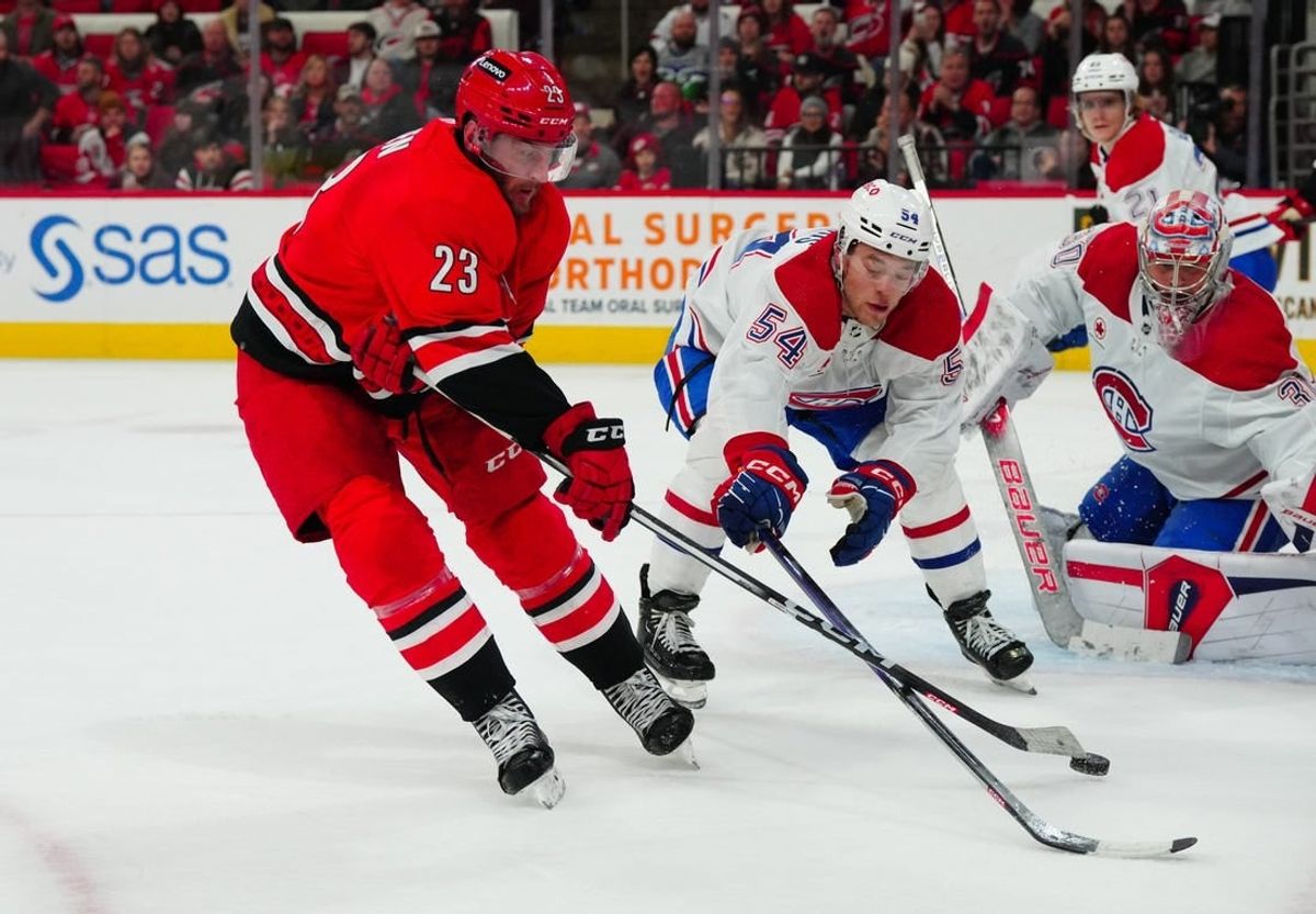 Dec 28, 2023; Raleigh, North Carolina, USA; Carolina Hurricanes right wing Stefan Noesen (23) ties to get his shot by Montreal Canadiens defenseman Jordan Harris (54) during the third period at PNC Arena.