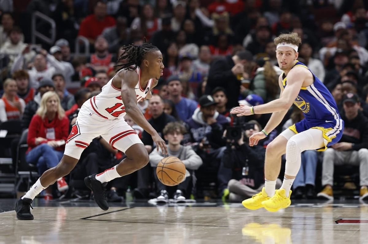Jan 12, 2024; Chicago, Illinois, USA; Chicago Bulls guard Ayo Dosunmu (12) drives against Golden State Warriors guard Brandin Podziemski (2) during the first half at United Center.
