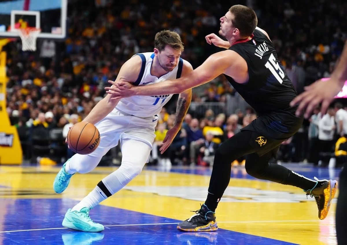 Nov 3, 2023; Denver, Colorado, USA; Denver Nuggets center Nikola Jokic (15) fouls Dallas Mavericks guard Luka Doncic (77) in the third quarter at Ball Arena.
