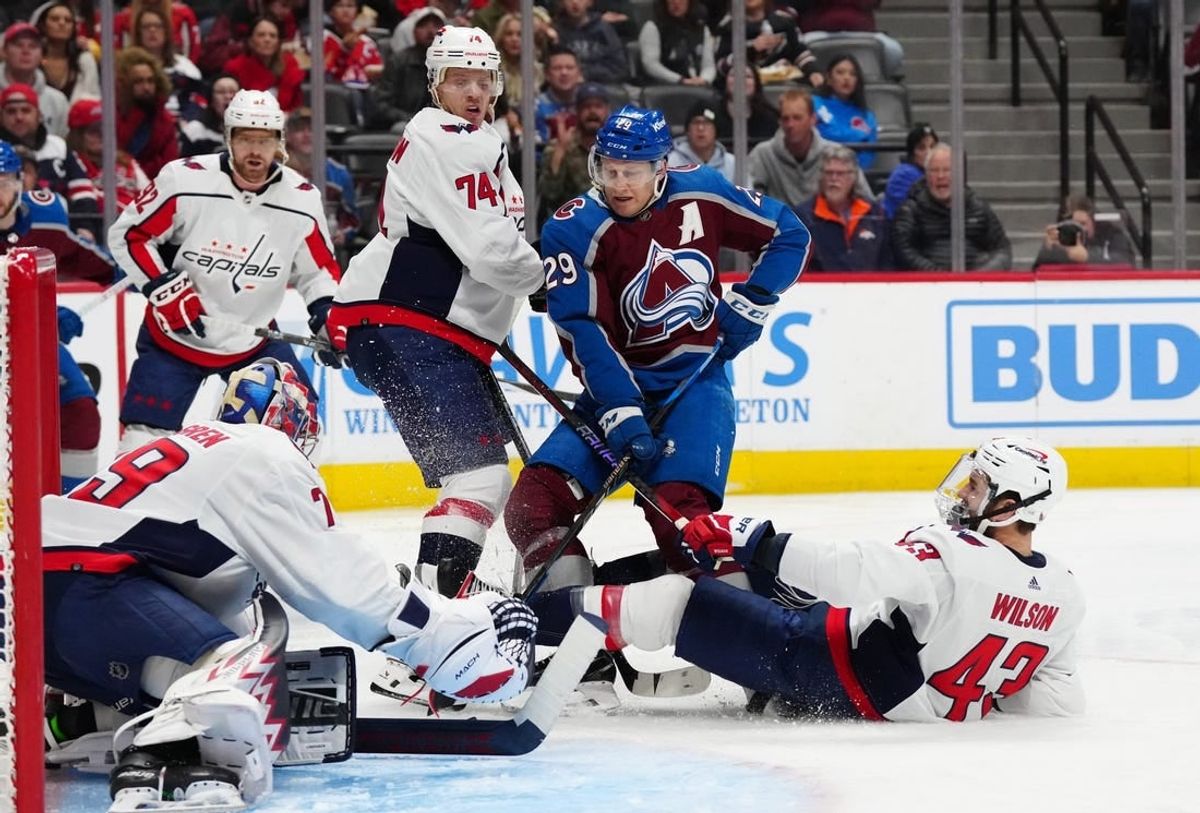 Jan 24, 2024; Denver, Colorado, USA; Colorado Avalanche center Nathan MacKinnon (29) shoots on Washington Capitals defenseman John Carlson (74) and goaltender Charlie Lindgren (79) and right wing Tom Wilson (43) in the second period at Ball Arena.