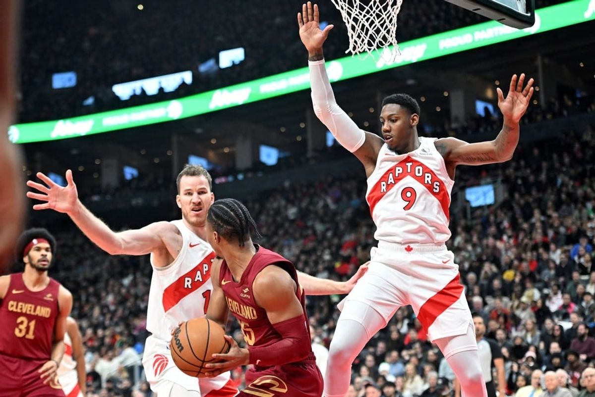 Jan 1, 2024; Toronto, Ontario, CAN; Toronto Raptors center Jakob Poeltl (19) and forward RJ Barrett (9) defend their basket as Cleveland Cavaliers guard Isaac Okoro (35) looks to make a pass in the first half at Scotiabank Arena.