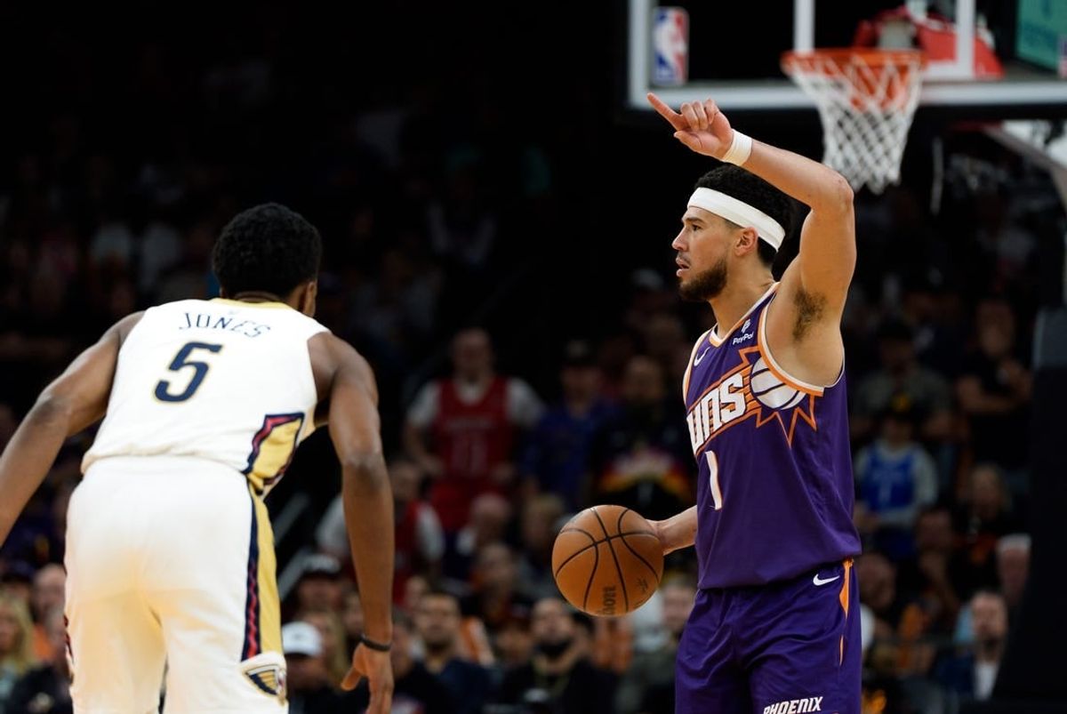 Apr 7, 2024; Phoenix, Arizona, USA;  Phoenix Suns guard Devin Booker (1) calls out a play as he bring the ball down the court against the New Orleans Pelicans in the second half at Footprint Center.