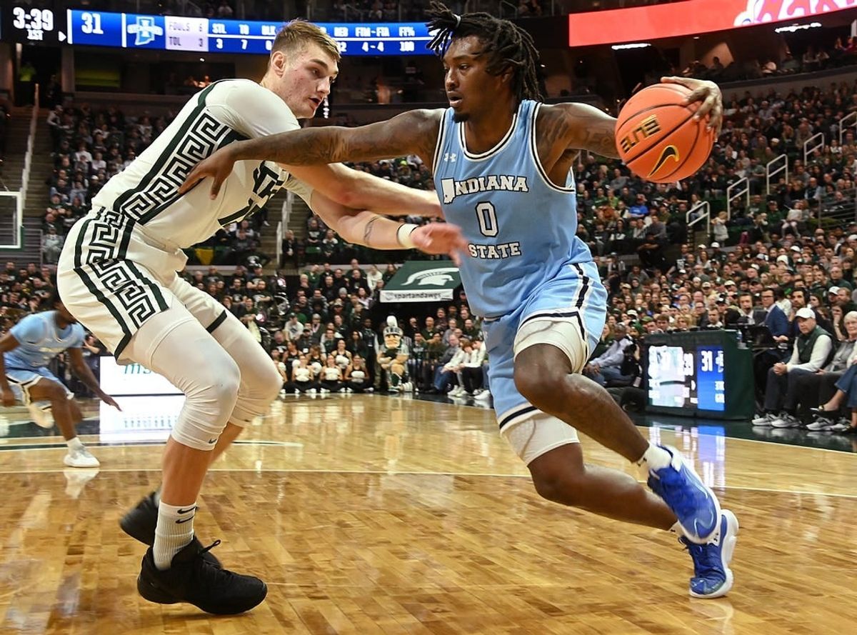 Dec 30, 2023; East Lansing, Michigan, USA; Indiana State Sycamores guard Xavier Bledson (0) drives against Michigan State Spartans center Carson Cooper (15) during the first half at Jack Breslin Student Events Center.