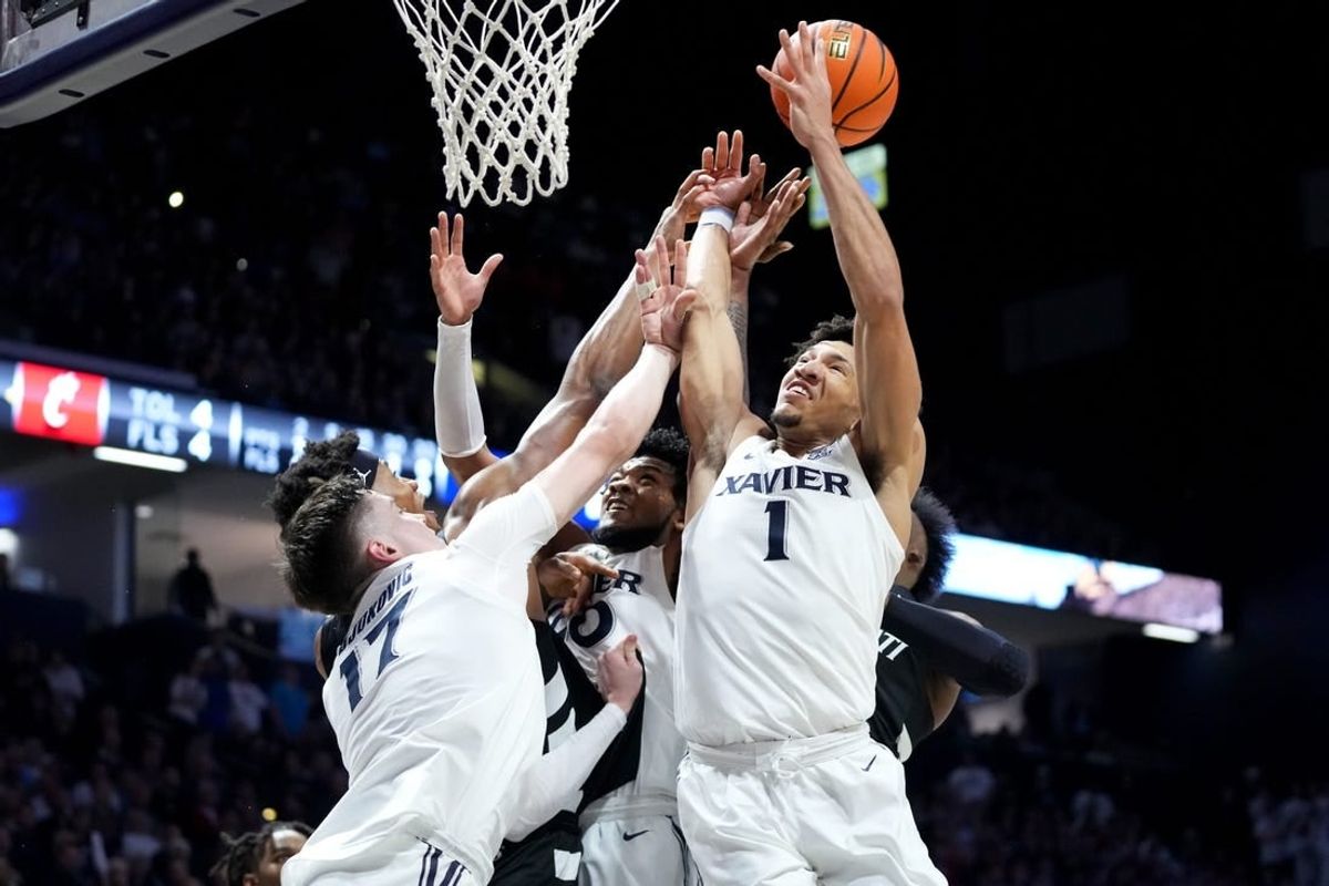 Xavier Musketeers forward Lazar Djokovic (17), Cincinnati Bearcats forward Ody Oguama (33), Xavier Musketeers guard Dayvion McKnight (20), Xavier Musketeers guard Desmond Claude (1) and Cincinnati Bearcats forward John Newman III (15) compete for a rebound in the first half of the 91st Crosstown Shootout basketball game between the Cincinnati Bearcats and the Xavier Musketeers, Saturday, Dec. 9, 2023, at Cintas Center in Cincinnati.