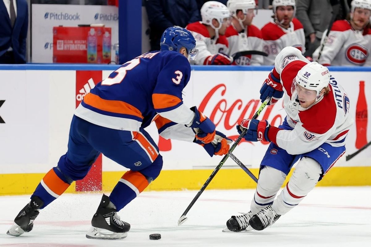 Apr 12, 2023; Elmont, New York, USA; Montreal Canadiens center Rem Pitlick (32) and New York Islanders defenseman Adam Pelech (3) fight for the puck during the first period at UBS Arena.