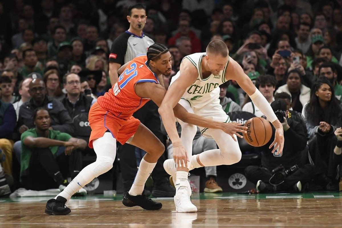 Apr 3, 2024; Boston, Massachusetts, USA; Oklahoma City Thunder guard Aaron Wiggins (21) pokes the ball from Boston Celtics center Kristaps Porzingis (8) during the first half at TD Garden.