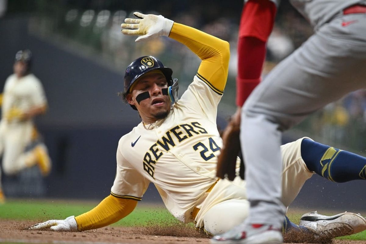 May 10, 2024; Milwaukee, Wisconsin, USA; Milwaukee Brewers shortstop Willy Adames (27) slides in safely to third base ahead of the tag of St. Louis Cardinals third base Nolan Arenado (28) in the seventh inning at American Family Field.
