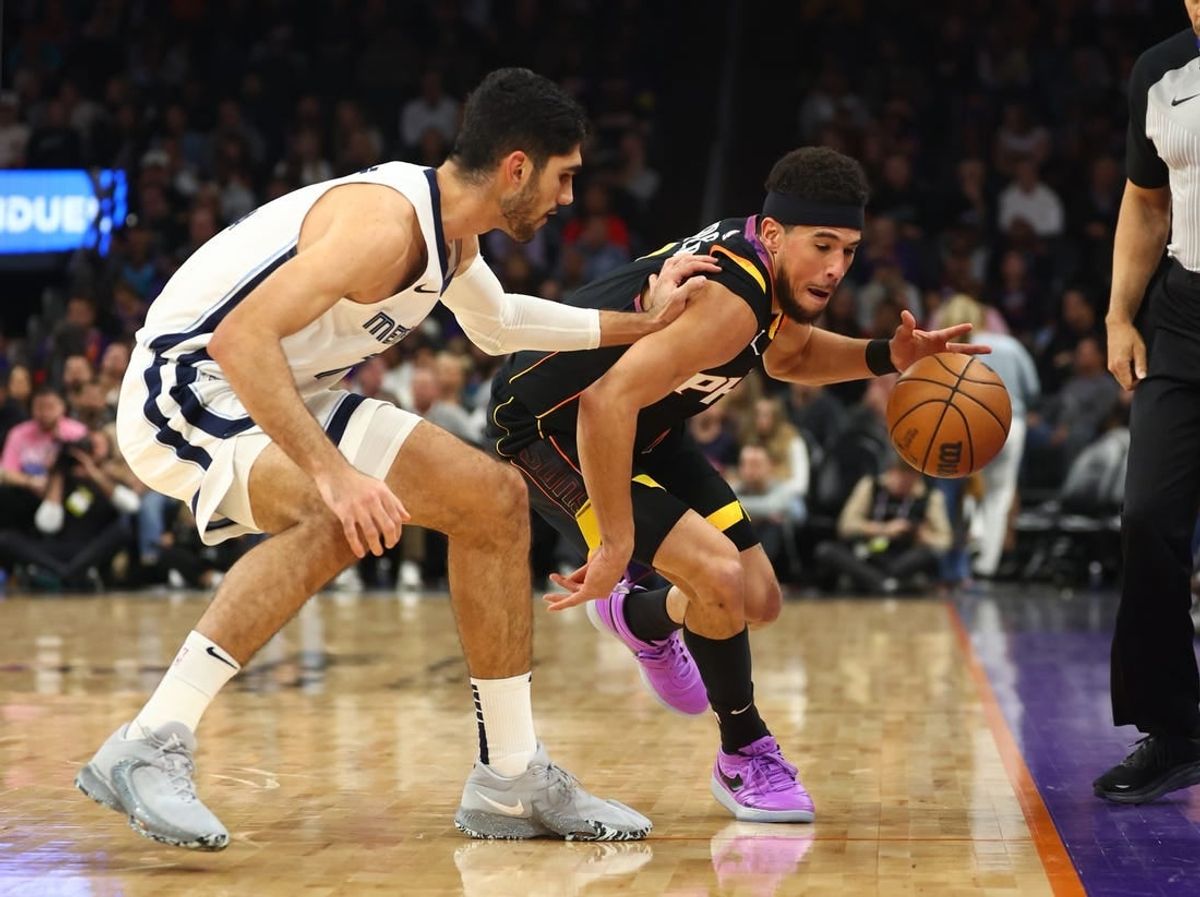 Dec 2, 2023; Phoenix, Arizona, USA; Phoenix Suns guard Devin Booker (right) steals the ball from Memphis Grizzlies forward Santi Aldama in the first half at Footprint Center.