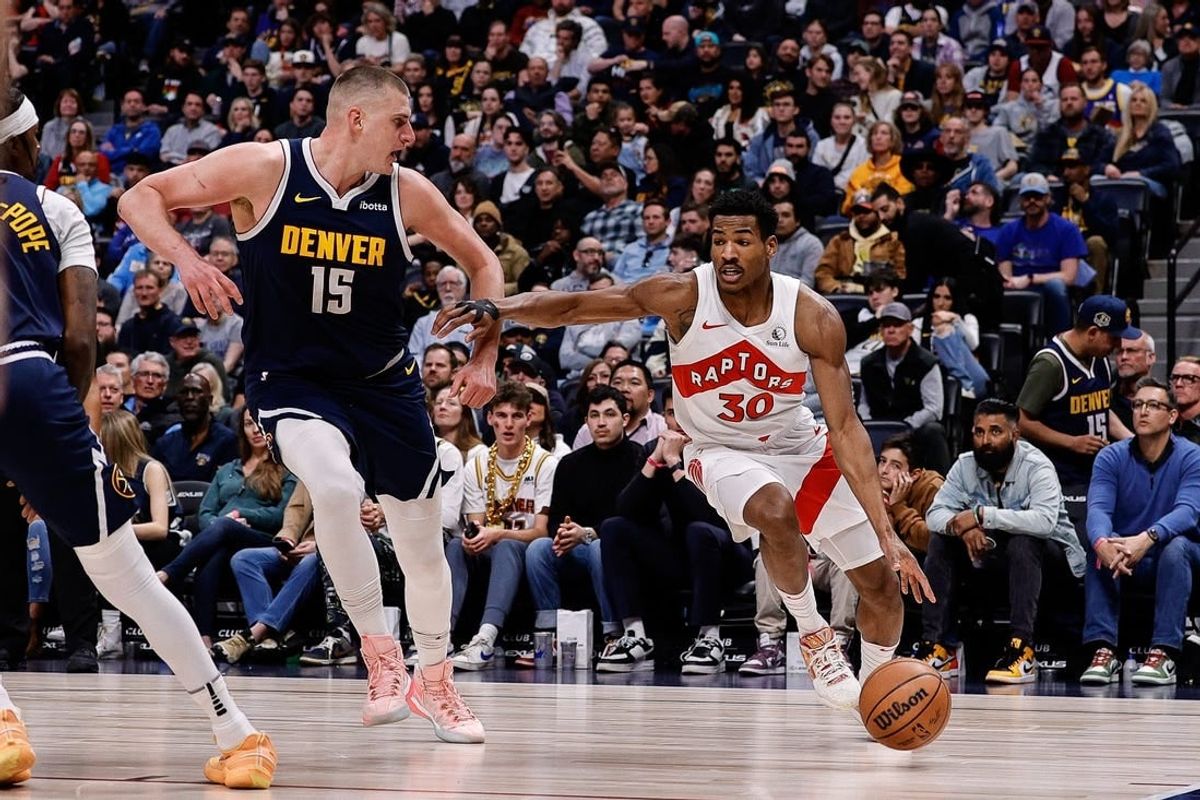Mar 11, 2024; Denver, Colorado, USA; Toronto Raptors guard Ochai Agbaji (30) drives to the basket against Denver Nuggets center Nikola Jokic (15) in the second quarter at Ball Arena.