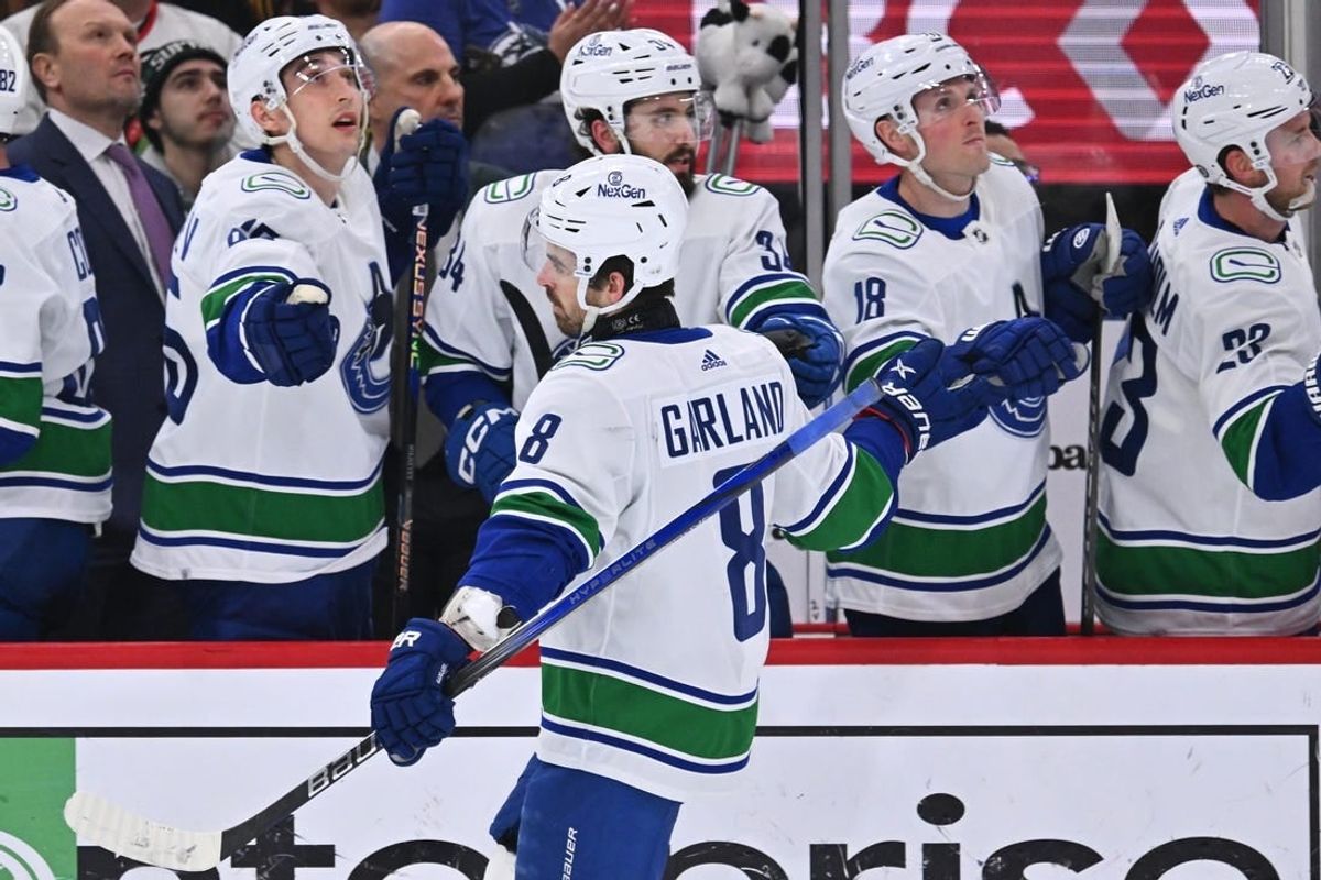 Feb 13, 2024; Chicago, Illinois, USA;  Vancouver Canucks forward Conor Garland (8) celebrates with the bench after scoring a goal in the first period against the Chicago Blackhawks at United Center.