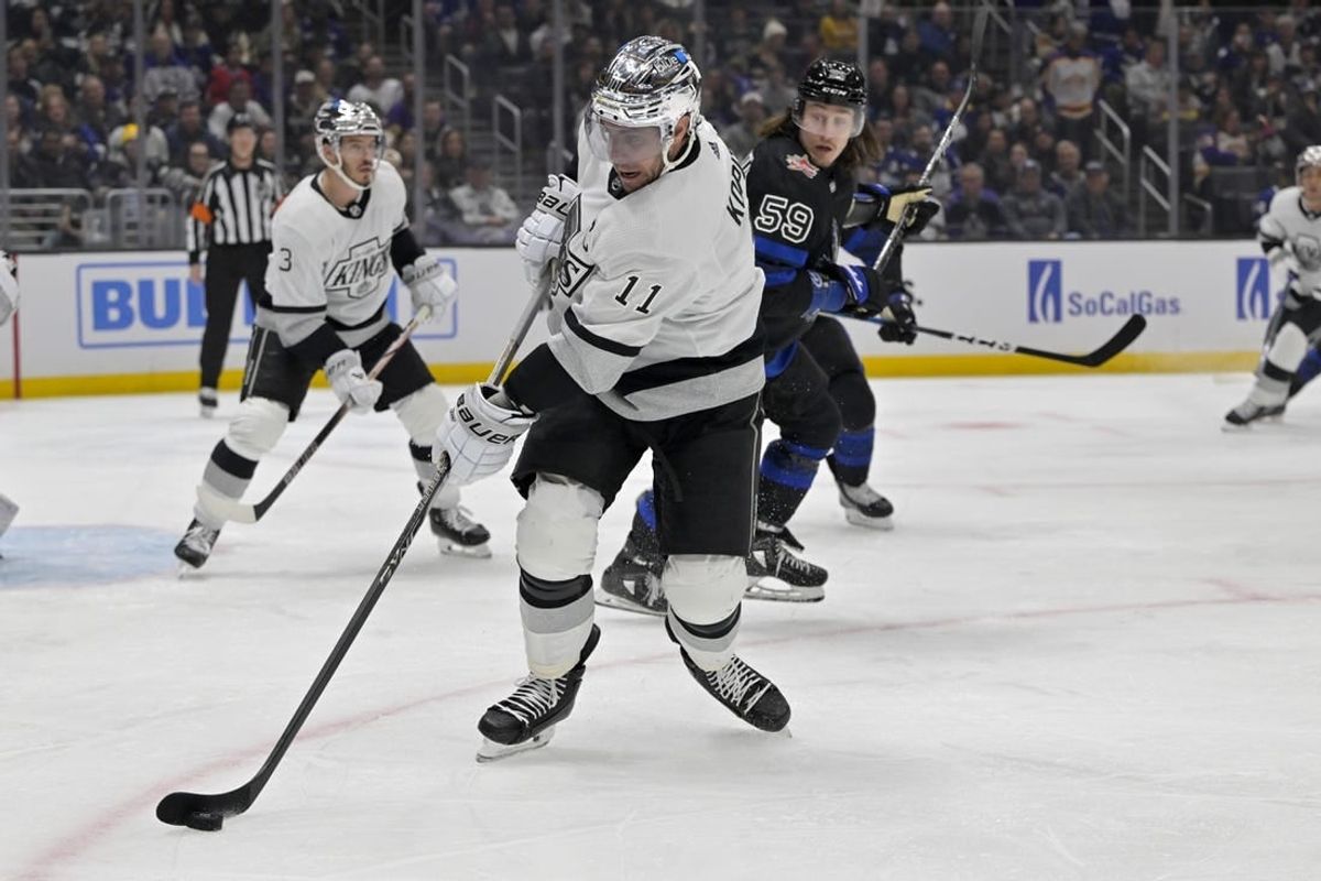 Jan 2, 2024; Los Angeles, California, USA; Los Angeles Kings center Anze Kopitar (11) keeps the puck from Toronto Maple Leafs left wing Tyler Bertuzzi (59) in the first period at Crypto.com Arena.