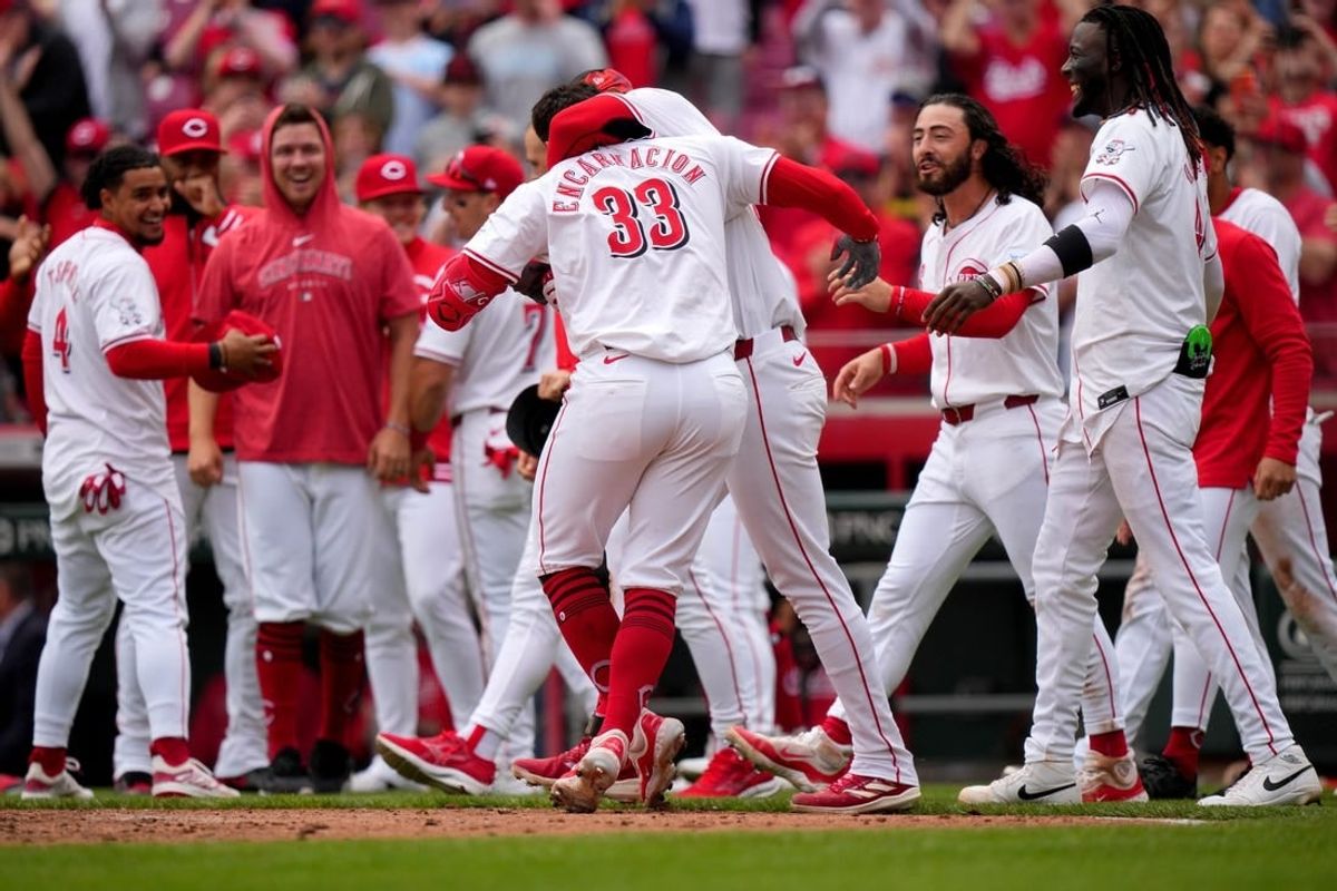 Cincinnati Reds center fielder Will Benson (30) embraces Cincinnati Reds first baseman Christian Encarnacion-Strand (33) after he hit a walk-off home run in the ninth inning of a baseball game against the Washington Nationals, Sunday, March 31, 2024, at Great American Ball Park in Cincinnati.