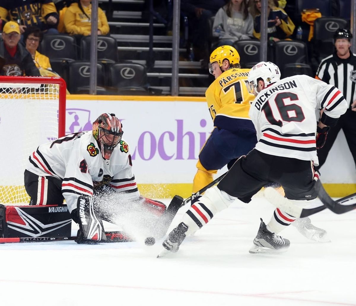 Nov 18, 2023; Nashville, Tennessee, USA;  Nashville Predators player Juuso Parssinen (75) shoots against Chicago Blackhawks players Arvid Soderblom (40) and player Jason Dickinson (16) during the first period of their game at Bridgestone Arena.