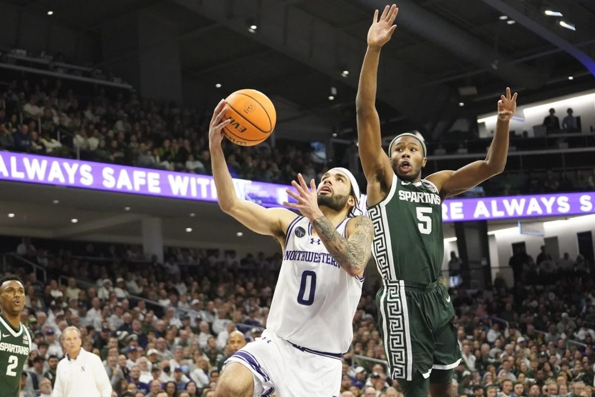 Jan 7, 2024; Evanston, Illinois, USA; Michigan State Spartans guard Tre Holloman (5) defends Northwestern Wildcats guard Boo Buie (0) during the second half at Welsh-Ryan Arena.