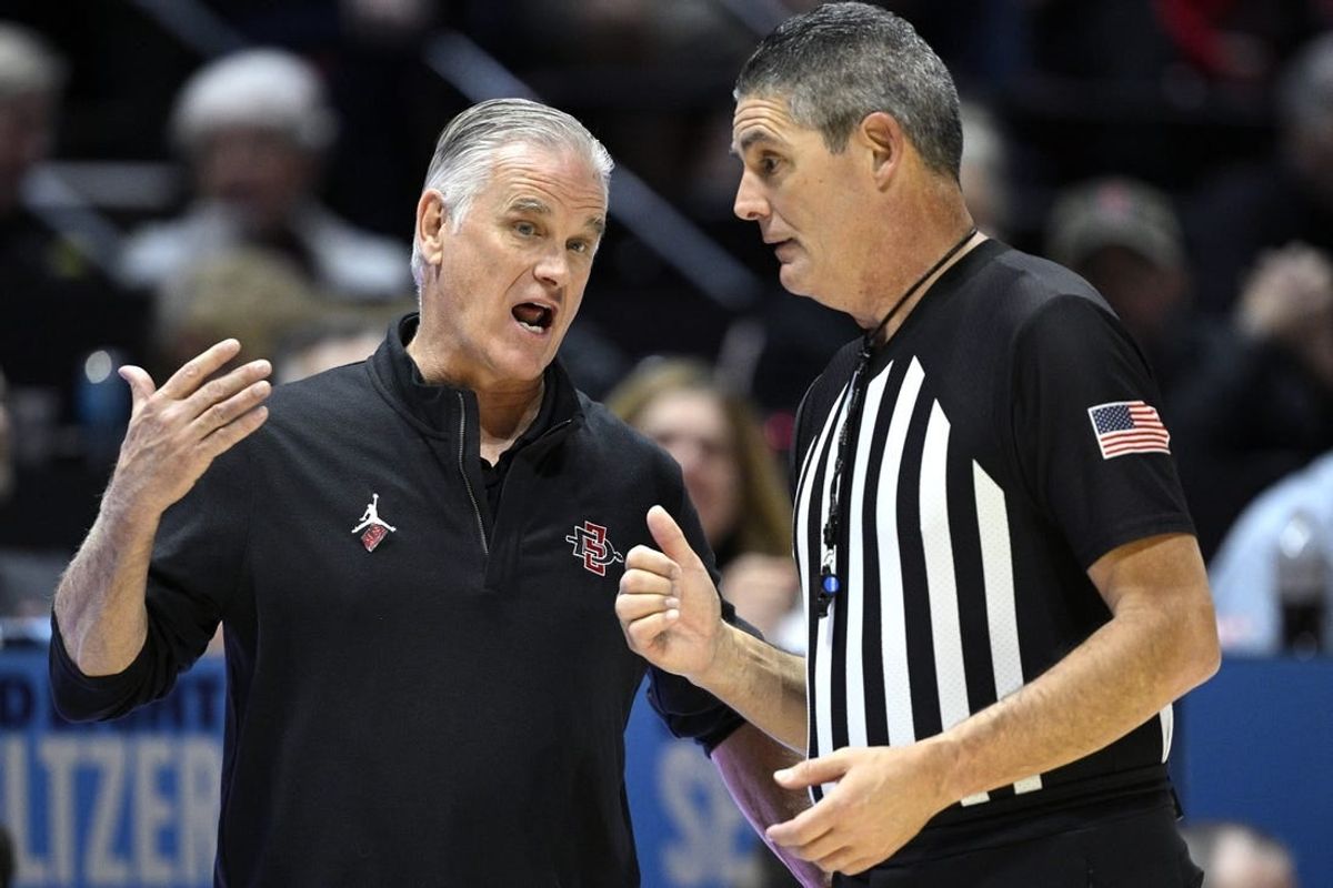 Jan 6, 2024; San Diego, California, USA; San Diego State Aztecs head coach Brian Dutcher (left) speaks with referee Michael Reed during the second half against the UNLV Rebels at Viejas Arena.