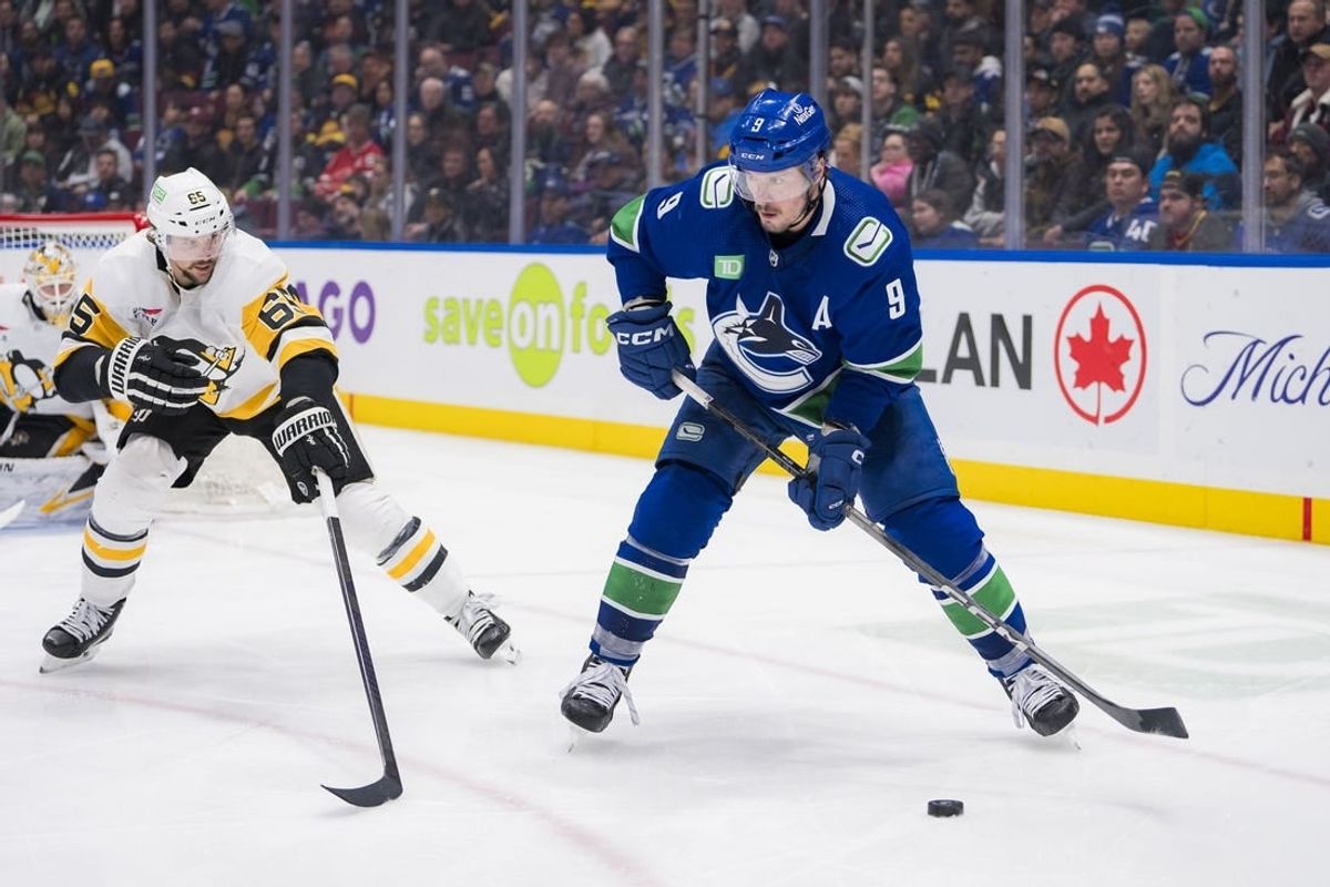 Feb 27, 2024; Vancouver, British Columbia, CAN; Pittsburgh Penguins defenseman Erik Karlsson (65) defends against Vancouver Canucks forward J.T. Miller (9) in the third period at Rogers Arena. Penguins won 4-3 in overtime.