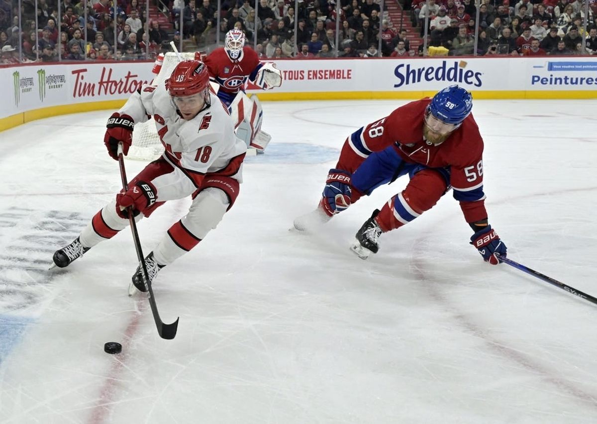 Mar 30, 2024; Montreal, Quebec, CAN; Carolina Hurricanes forward Jack Drury (18) plays the puck and Montreal Canadiens defenseman David Savard (58) defends during the first period at the Bell Centre.