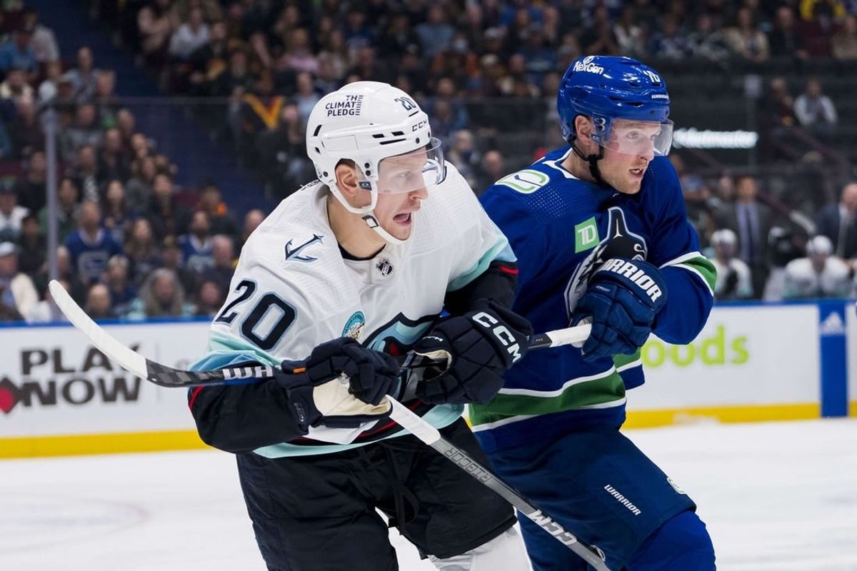 Nov 18, 2023; Vancouver, British Columbia, CAN; Seattle Kraken forward Eeli Tolvanen (20) battles with Vancouver Canucks forward Sam Lafferty (18) in the third period at Rogers Arena. Seattle won 4-3.