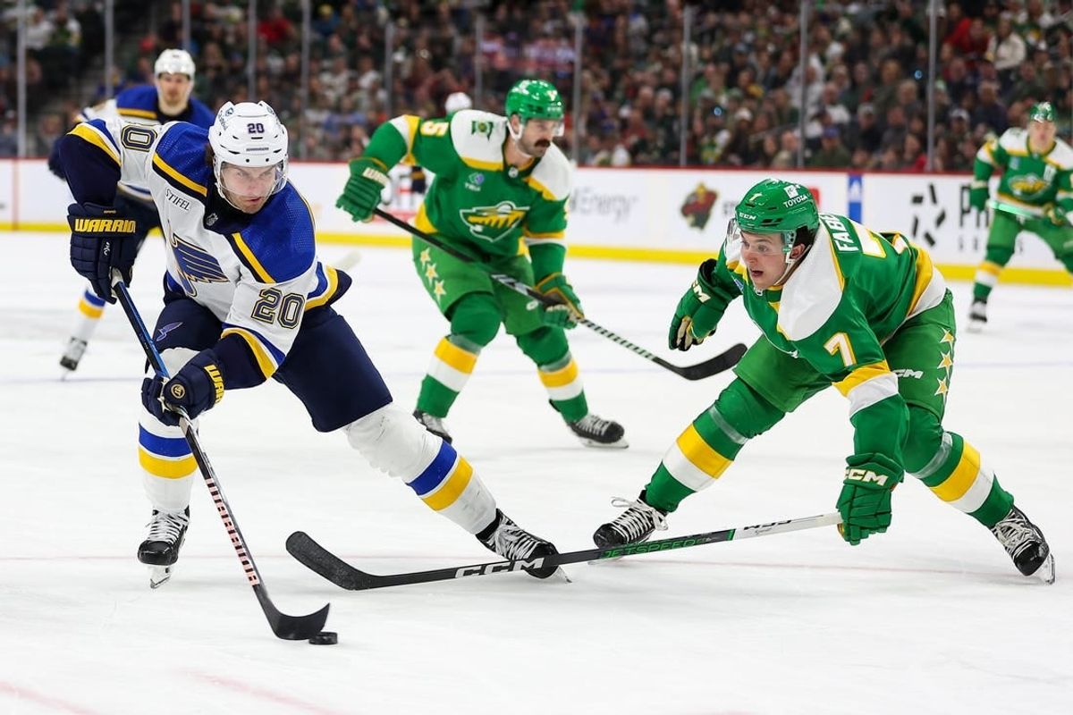 Mar 23, 2024; Saint Paul, Minnesota, USA; St. Louis Blues left wing Brandon Saad (20) skates around Minnesota Wild defenseman Brock Faber (7) during the second period at Xcel Energy Center.