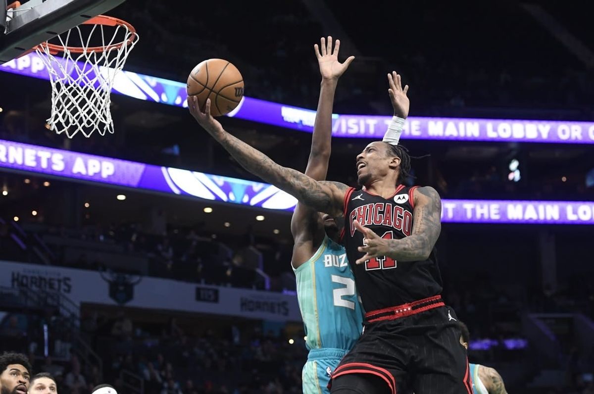 Jan 31, 2024; Charlotte, North Carolina, USA;  Chicago Bulls guard DeMar DeRozan (11) drives in for a lay-up past Charlotte Hornets forward guard Brandon Miller (24) during the second half at the Spectrum Center.