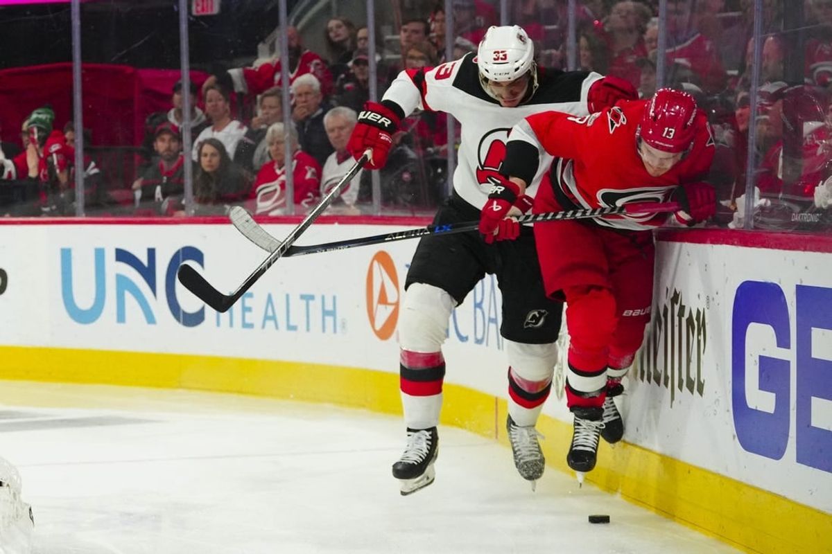 May 3, 2023; Raleigh, North Carolina, USA; New Jersey Devils defenseman Ryan Graves (33) checks Carolina Hurricanes right wing Jesse Puljujarvi (13) during the third period in game one of the second round of the 2023 Stanley Cup Playoffs at PNC Arena.