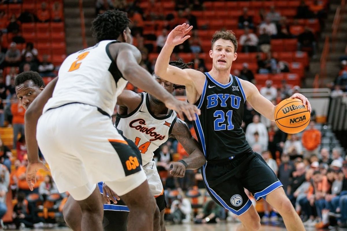 Feb 17, 2024; Stillwater, Oklahoma, USA; Brigham Young Cougars guard Trevin Knell (21) drives to the basket around Oklahoma State Cowboys guard Jamyron Keller (14) and Oklahoma State Cowboys forward Eric Dailey Jr. (2) during the second half at Gallagher-Iba Arena.