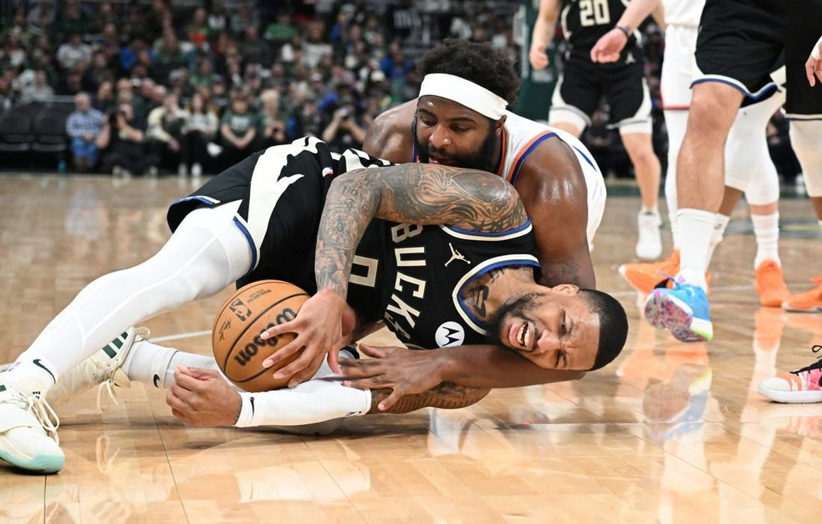 Apr 7, 2024; Milwaukee, Wisconsin, USA; Milwaukee Bucks guard Damian Lillard (0) and New York Knicks center Mitchell Robinson (23) battle for a loose ball in the first half at Fiserv Forum.