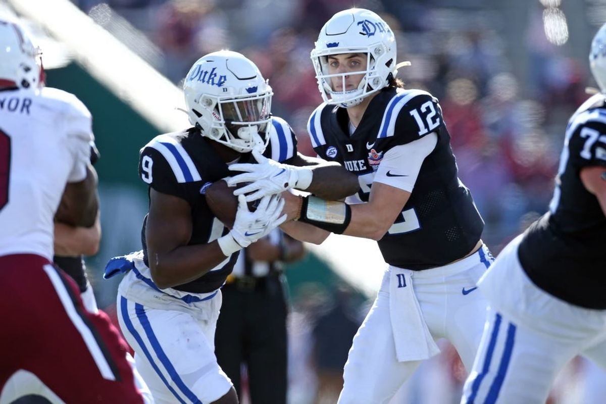 Dec 23, 2023; Birmingham, AL, USA; Duke Blue Devils quarterback Grayson Loftis (12) hands the ball off to Duke Blue Devils running back Jaquez Moore (9) during the first half against the Troy Trojans at Protective Stadium.