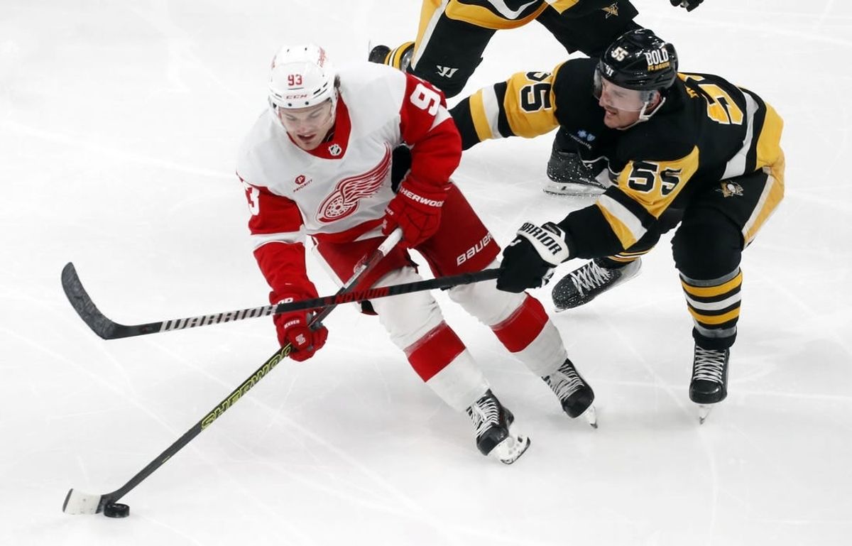 Mar 17, 2024; Pittsburgh, Pennsylvania, USA;  Detroit Red Wings right wing Alex DeBrincat (93) skates with he puck against Pittsburgh Penguins center Noel Acciari (55) during the third period at PPG Paints Arena. Pittsburgh won 6-3.