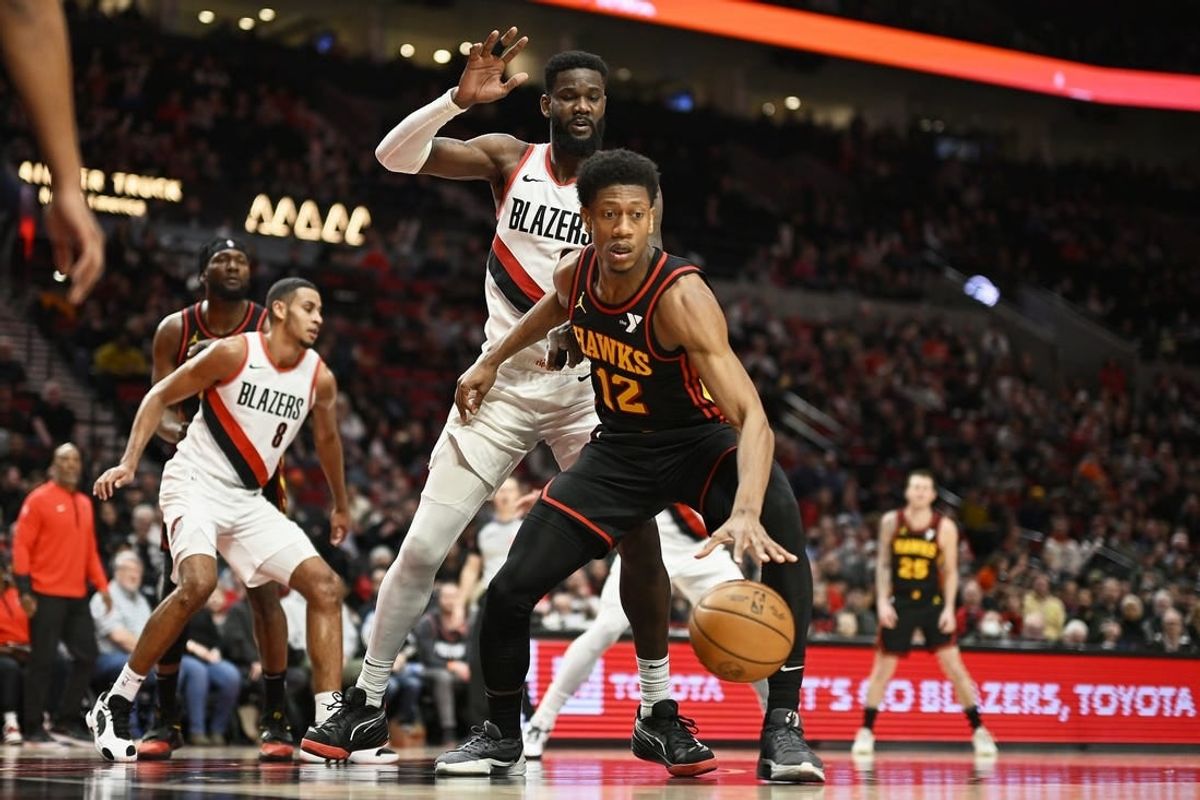 Mar 13, 2024; Portland, Oregon, USA; Atlanta Hawks forward De'Andre Hunter (12) dribbles the basketball during the second half against Portland Trail Blazers center Deandre Ayton (2) at Moda Center.