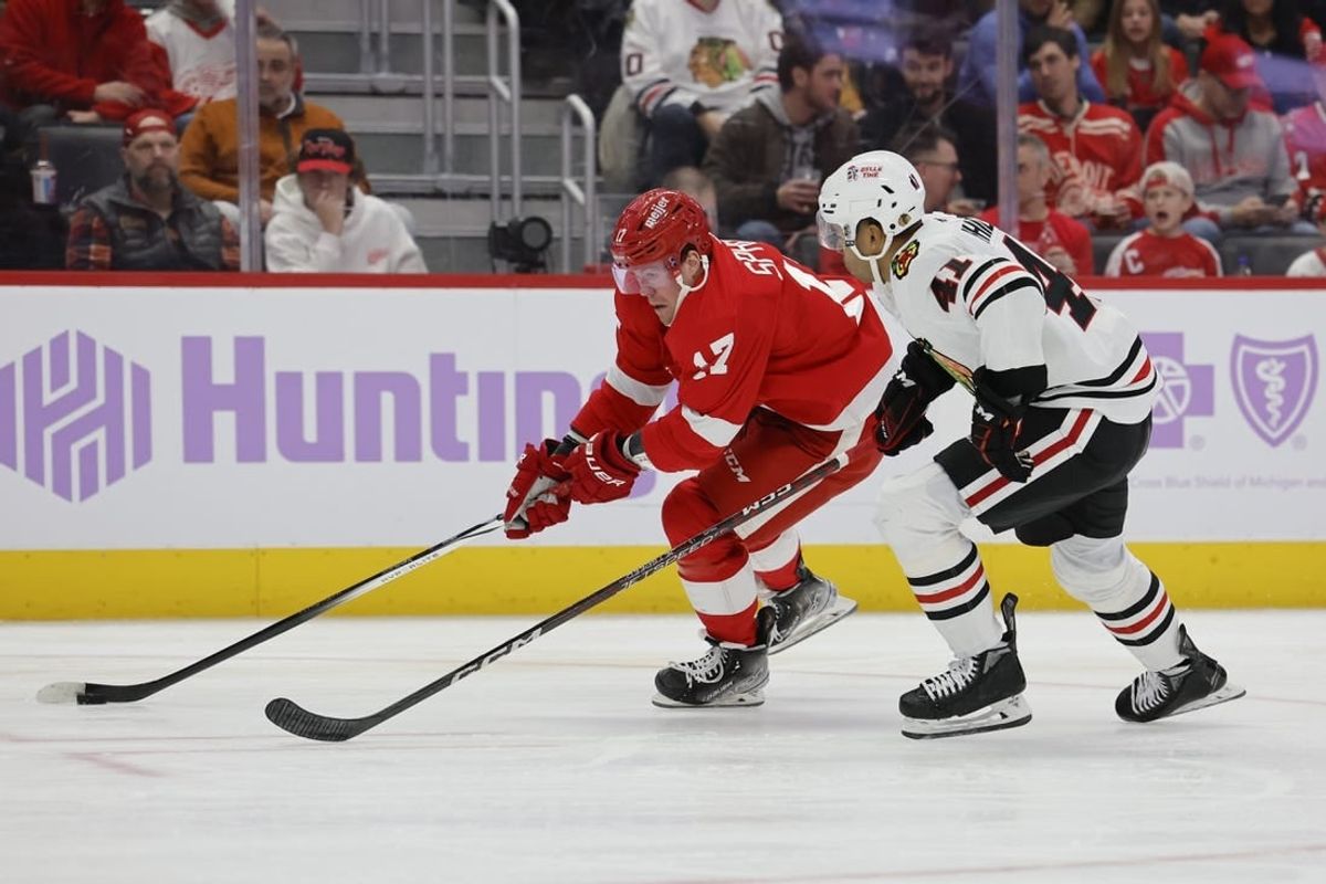 Nov 30, 2023; Detroit, Michigan, USA; Detroit Pistons guard Stanley Umude (17) skates with the puck defended by Chicago Blackhawks defenseman Isaak Phillips (41) in the second period at Little Caesars Arena.