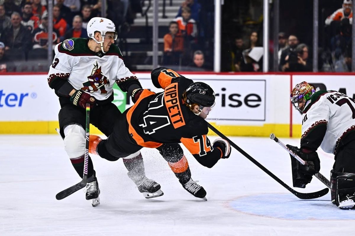 Feb 12, 2024; Philadelphia, Pennsylvania, USA; Philadelphia Flyers right wing Owen Tippett (74) falls after a hit from Arizona Coyotes defenseman Travis Dermott (33) in the first period at Wells Fargo Center.
