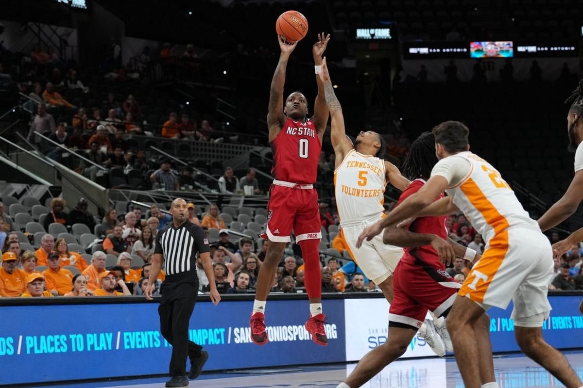 Dec 16, 2023; San Antonio, Texas, USA;  North Carolina State Wolfpack guard DJ Horne (0) shoots over Tennessee Volunteers guard Zakai Zeigler (5) in the first half at the Frost Bank Center.