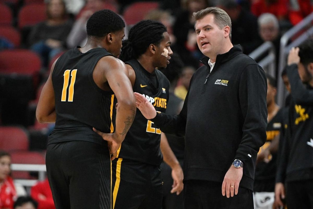 Nov 15, 2022; Louisville, Kentucky, USA;  Appalachian State Mountaineers head coach Dustin Kerns talks with forward Donovan Gregory (11) and guard Terence Harcum (23) during the first half against the Louisville Cardinals at KFC Yum! Center. Appalachian State defeated Louisville 61-60.