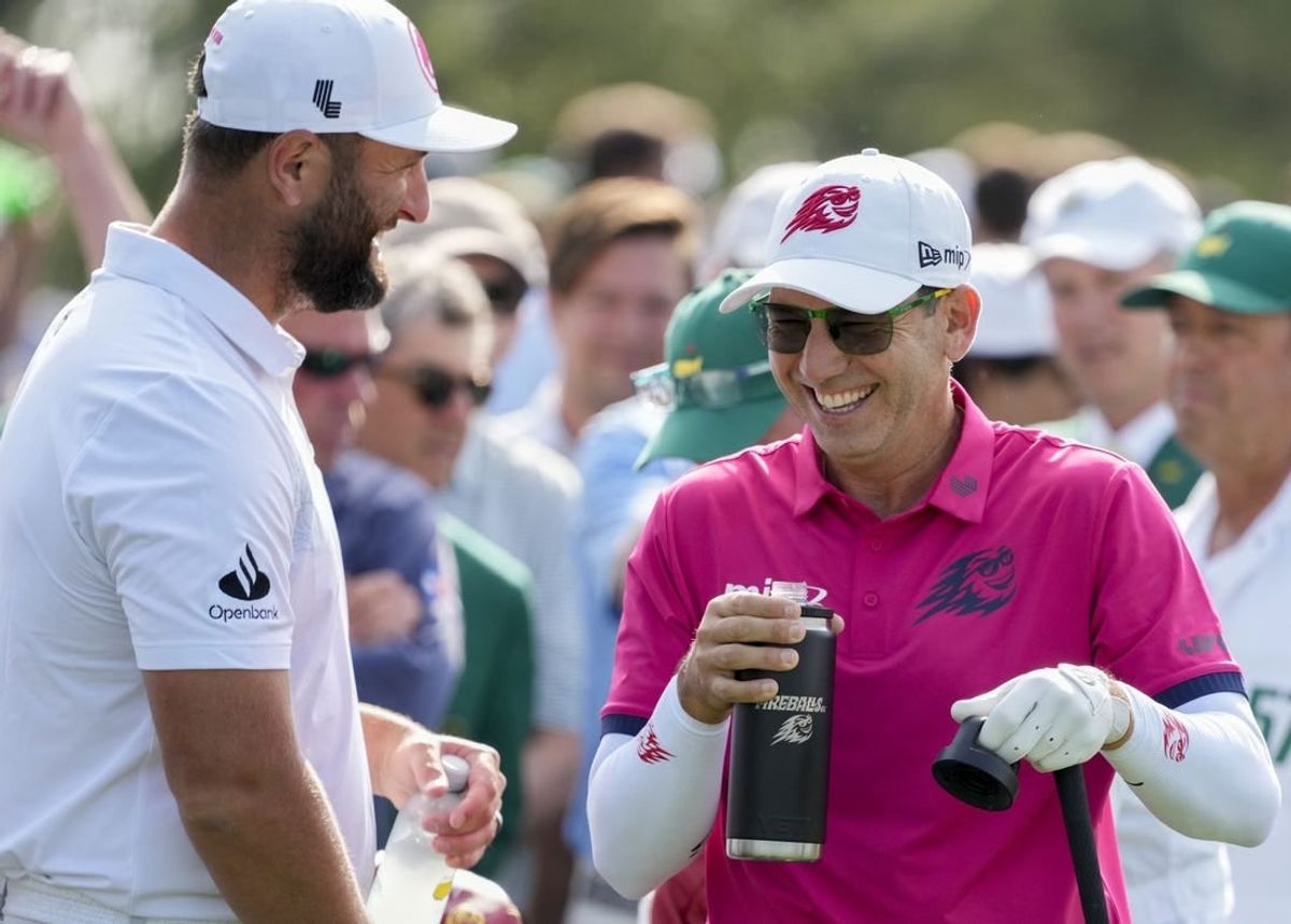Apr 10, 2024; Augusta, Georgia, USA; Jon Rahm and Sergio Garcia laugh at the no. 1 tee during a practice round at Augusta National Golf Club.