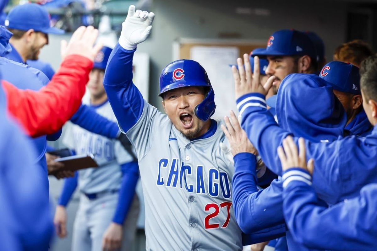 Apr 13, 2024; Seattle, Washington, USA; Chicago Cubs right fielder Seiya Suzuki (27) high-fives teammates in the dugout after hitting a solo-home run against the Seattle Mariners during the third inning at T-Mobile Park.