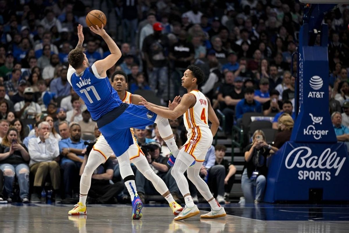 Apr 4, 2024; Dallas, Texas, USA; Dallas Mavericks guard Luka Doncic (77) is fouled as he shoots over Atlanta Hawks guard Kobe Bufkin (4) during the first half at the American Airlines Center.