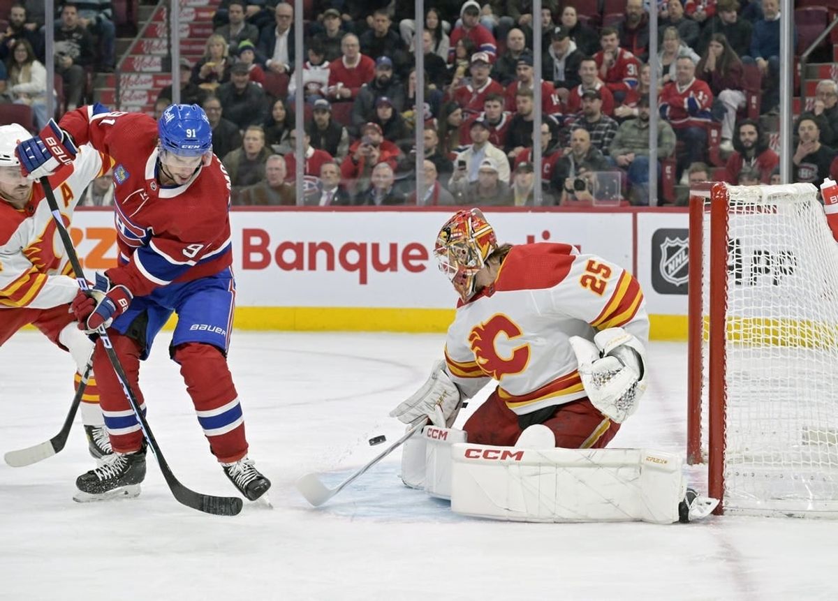 Nov 14, 2023; Montreal, Quebec, CAN; Calgary Flames goalie Jacob Markstrom (25) stops Montreal Canadiens forward Sean Monahan (91) during the first period at the Bell Centre.