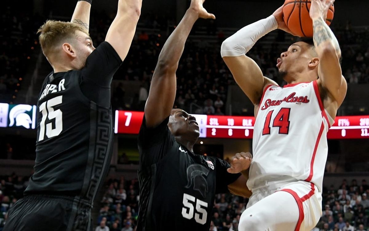 Dec 21, 2023; East Lansing, Michigan, USA; Stony Brook Seawolves guard Tyler Stephenson-Moore (14)can   t see an open shot past the defense of Michigan State Spartans forward Coen Carr (55) and Michigan State Spartans center Carson Cooper (15) at Jack Breslin Student Events Center.