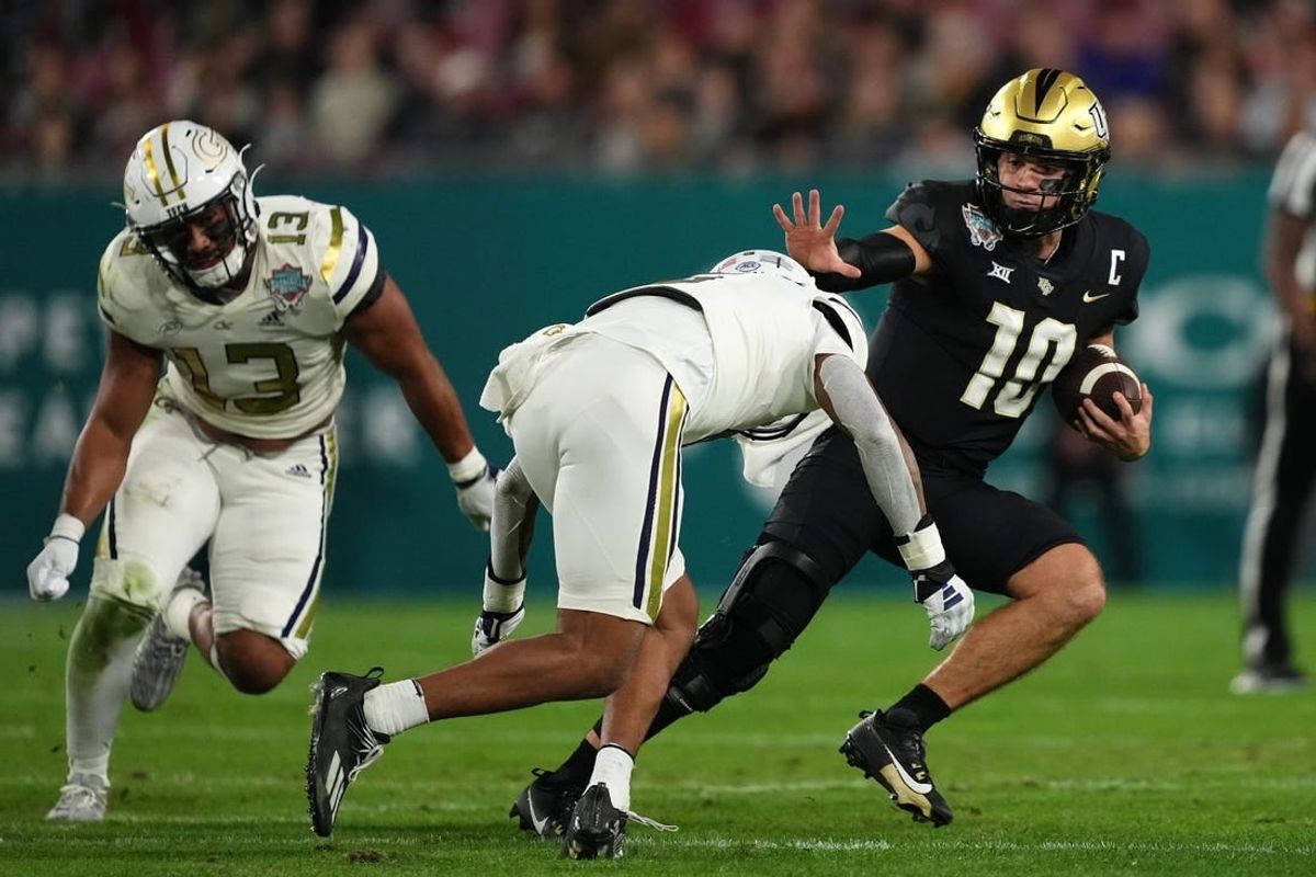 Dec 22, 2023; Tampa, FL, USA; UCF Knights quarterback John Rhys Plumlee (10) runs the ball around Georgia Tech Yellow Jackets defensive back Clayton Powell-Lee (5) during the first half of the Gasparilla Bowl at Raymond James Stadium.