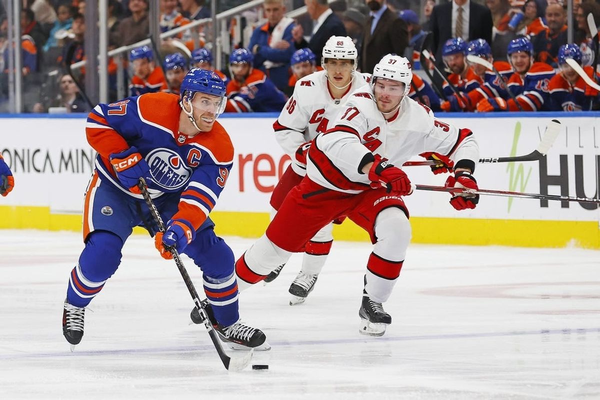 Dec 6, 2023; Edmonton, Alberta, CAN; Edmonton Oilers forward Connor McDavid (97) looks to make a pass in front of Carolina Hurricanes forward Andrei Svechnikov (37) during the third period at Rogers Place.
